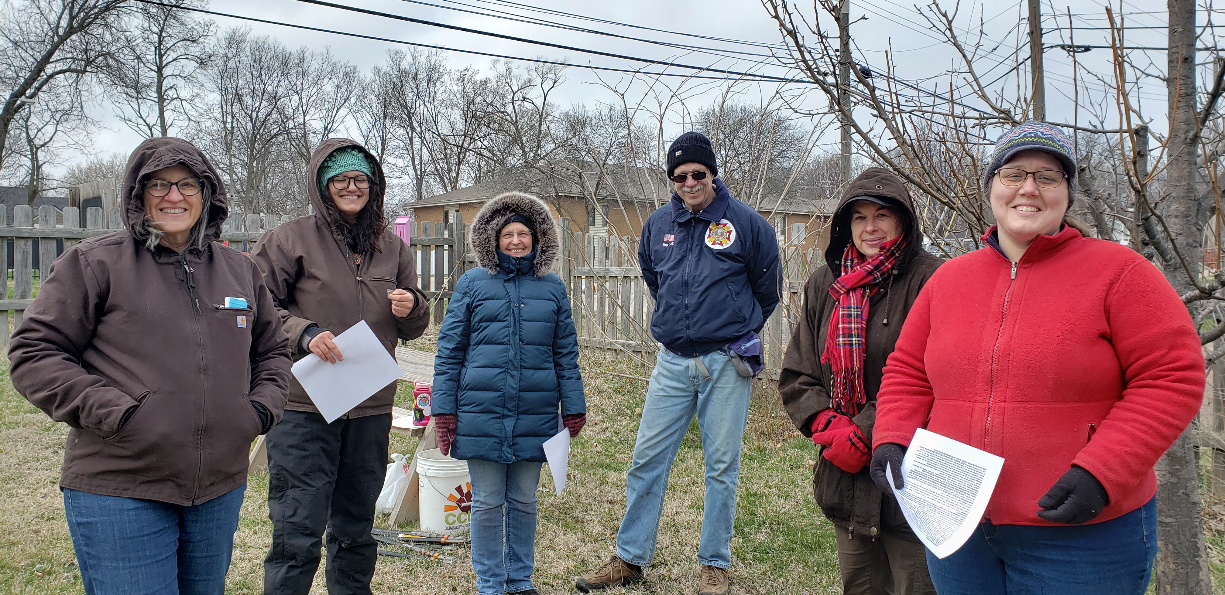 participants in an elderberry pruning workshop pose for a photo in the Kilgore's garden, bundled up against cold weather
